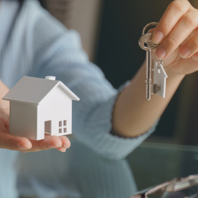 woman holding home model and keys