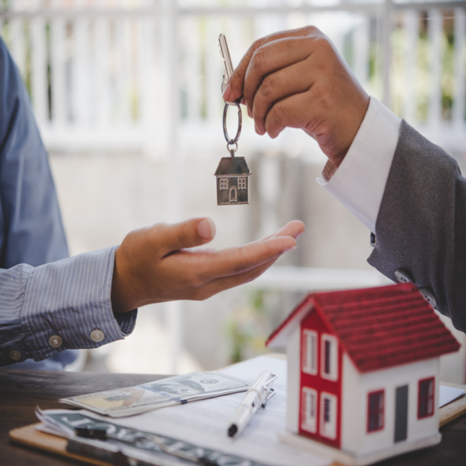 real estate agent handing buyer keys to home